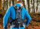 Homme qui utilise sont sac d'hydratation pendant un trail